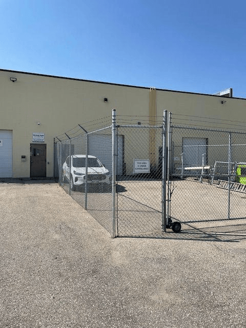 Chain link security fence and vehicle gate outside a commercial building